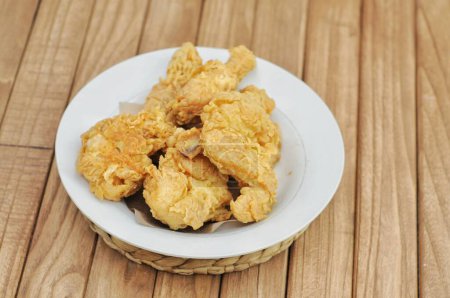 Photo for Crispy fried chicken served on a white plate on a wooden table - Royalty Free Image