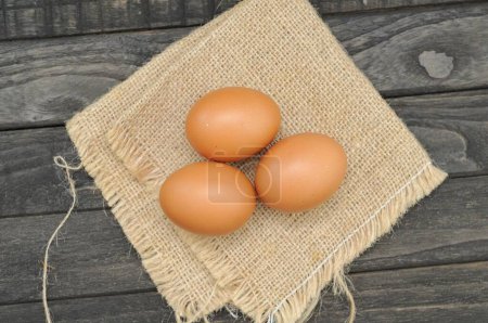 Photo for Chicken eggs on burlap and black table - Royalty Free Image