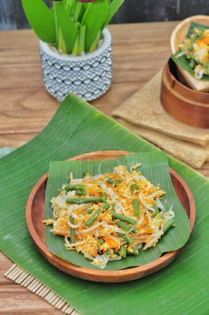 Photo for Selective focus Urap Sayur is Indonesian traditional food. a salad dish of steamed various vegetables mixed with seasoned and spiced, served on banana leaf and wood plate - Royalty Free Image