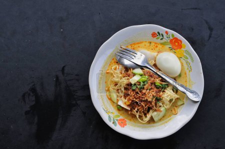Photo for Lontong noodles and eggs on white plate, wooden table background - Royalty Free Image