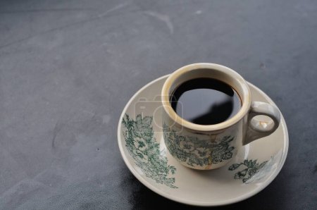 Téléchargez les photos : Tasse de café et une cuillère sur un fond noir - en image libre de droit