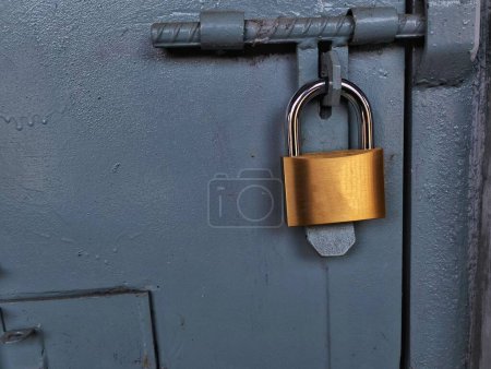 Photo for Gold-colored padlock on the iron door - Royalty Free Image