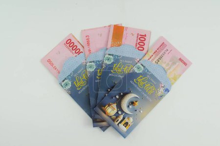 Téléchargez les photos : Monnaie indonésienne dans une enveloppe avec des motifs islamiques pour l'allocation de vacances - en image libre de droit