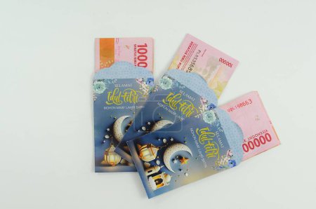 Téléchargez les photos : Monnaie indonésienne dans une enveloppe avec des motifs islamiques pour l'allocation de vacances - en image libre de droit