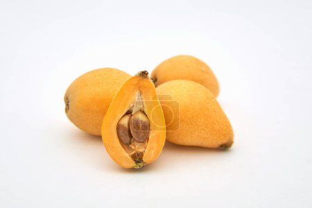 A pile of ripe loquats on a white background