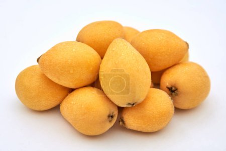 A pile of ripe loquats on a white background