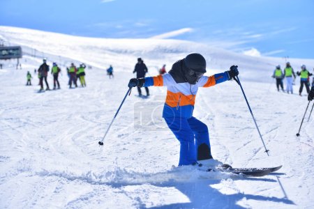 Téléchargez les photos : Skiing Technique: A Boy Mastering His Skills with a Quick Stop and a Spraying Snow Effect - en image libre de droit