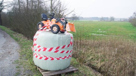Téléchargez les photos : Une barrière de piste sur une balle de foin pour symboliser les manifestations paysannes - en image libre de droit