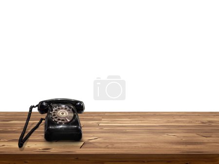 Foto de Viejo teléfono negro Colocado en mesa de madera aislada sobre fondo blanco - Imagen libre de derechos