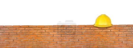 Gelber Schutzhelm rote Backsteinmauer