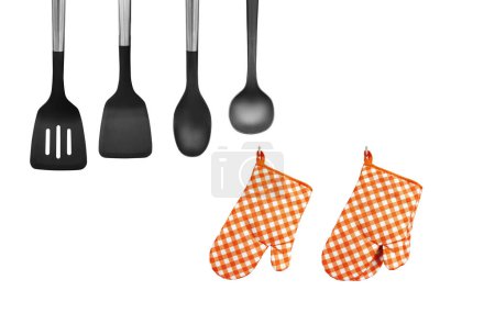 Orange heat resistant cooking gloves with kitchen utensils on wh