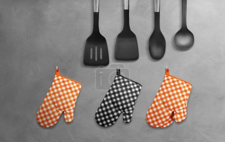 Guantes de cocina anaranjados resistentes al calor negros con utensilios de cocina