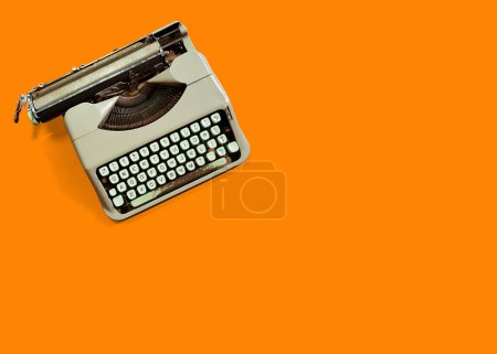 old typewriter isolated on orange background