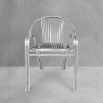 Modern style stainless steel chair for sitting isolated on cement background.