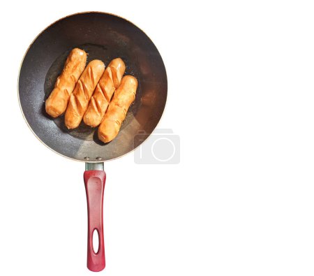 Sausages fried in a separate pan on white background and space for text . Top view.