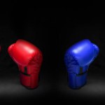 red boxing gloves blue against black background