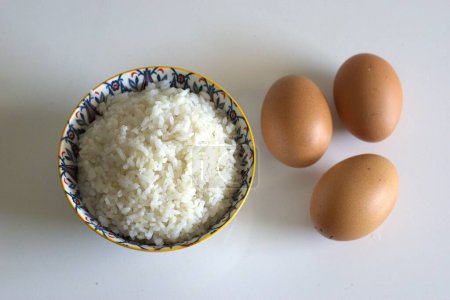 A bowl of rice and eggs on the table, cooking ingredient, top view image