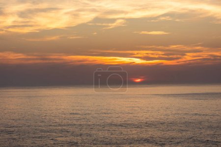 Landschaftsbild dramatischer, steiler orangefarbener Klippen am Atlantik bei Sonnenuntergang. Schüsse in Farol fo Cabo de Sao Vincente bei Sagres, Portugal.
