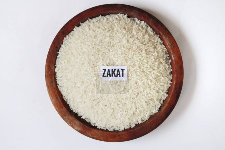 Rice in a wooden bowl on a white background.With copy space. Islamic Zakat concept.special during ramadan.