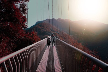 Photo for The Aya Teruha Great Suspension Bridge, Japan's largest pedestrian suspension bridge, rises 142 meters over the Aya River Valley in Miyazaki Province, overlooking the bridge's path.autumn. - Royalty Free Image