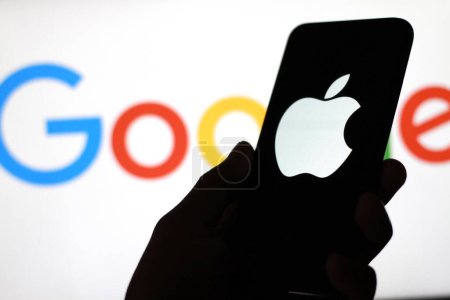 Photo for Indonesia - March 19th, 2024: Apple brand logo is displayed on the smartphone screen with the Google logo in the background. - Royalty Free Image