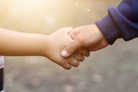 Photo for Children shaking hands on blurred background, Friendship, helping hand and peace concept with copy space - Royalty Free Image