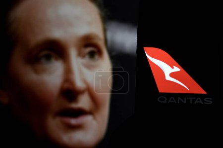 Téléchargez les photos : Indonésie-30 mars 2024 : Qantas logo est une compagnie aérienne australienne, affiché sur l'écran du smartphone avec PDG Vanessa Hudson en arrière-plan. - en image libre de droit