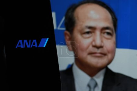 Foto de Indonesia - 2 de abril de 2024: El logotipo de ANA Airlines se muestra en la pantalla de un smartphone Con el CEO Shinichi Inoue en segundo plano. - Imagen libre de derechos