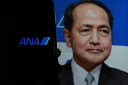 Foto de Indonesia - 2 de abril de 2024: El logotipo de ANA Airlines se muestra en la pantalla de un smartphone Con el CEO Shinichi Inoue en segundo plano. - Imagen libre de derechos