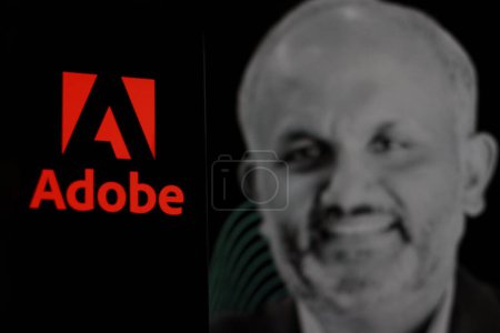 Foto de Indonesia-abril 2,2024: El logotipo de Adobe se muestra en la pantalla del teléfono inteligente Con el CEO Shantanu Narayen en segundo plano. - Imagen libre de derechos