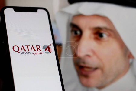 Téléchargez les photos : Indonésie - avril 7th, 2024 : Qatar Airways logo est affiché sur l'écran du smartphone Avec PDG Badr Mohammed Al Meer en arrière-plan - en image libre de droit