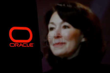 Photo for Indonesia - April 16th 2024: Logo of ORACLE is displayed on a smartphone screen with CEO Safra Catz in the background - Royalty Free Image