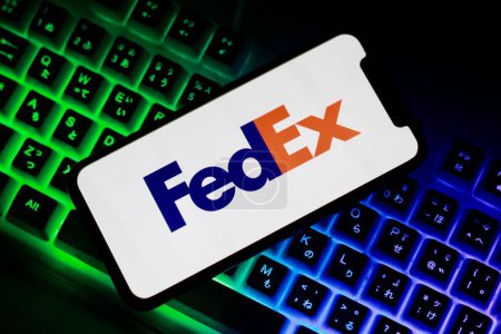 Téléchargez les photos : Le logo FedEx est affiché sur l'écran du Smartphone.indonesia-23 avril 2024. Clavier d'ordinateur sur fond - en image libre de droit