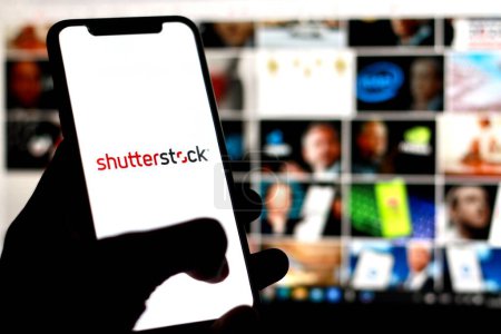 Photo for Indonesia-April,23,2024: Mobile phone with logo of US stock photography company Shutterstock Inc. on screen in front of website. Focus on center-right of phone display. Unmodified photo. - Royalty Free Image