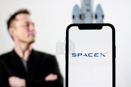 Téléchargez les photos : Sur cette photo, le logo Starlink est affiché sur l'écran du smartphone avec le PDG Elon Musk en arrière-plan - en image libre de droit