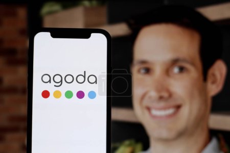 Téléchargez les photos : Dans cette illustration photo, le logo Agoda est affiché sur un smartphone avec le PDG Omri Morgenshtern en toile de fond.Indonésie - 25 mai 2024. - en image libre de droit