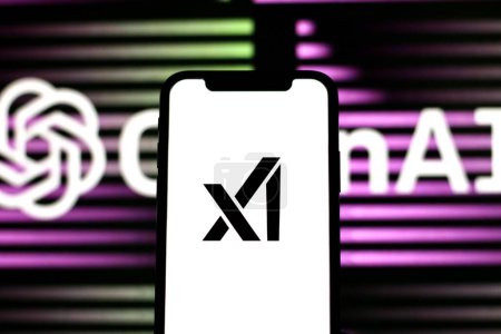 Foto de INDONESIA - 30 DE MAYO DE 2024: en esta foto el logotipo xAI se muestra en el teléfono inteligente con el logotipo openAI en el fondo, se muestra en una pantalla del teléfono inteligente - Imagen libre de derechos