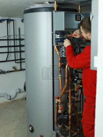 Ingeniero eléctrico conecta una bomba de calor. Foto de alta calidad