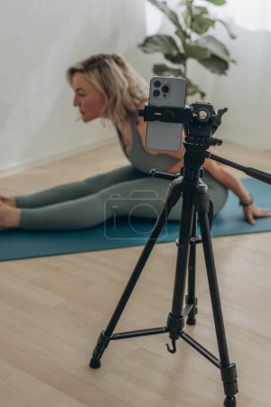 A 50-year-old woman doing online yoga at home. High quality photo