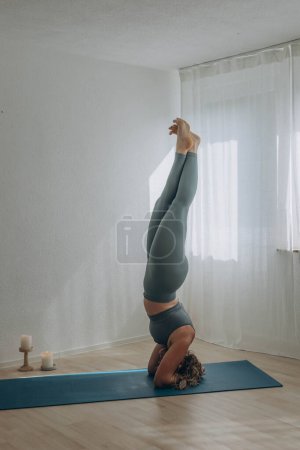 Una mujer de 50 años hace yoga en casa. Foto de alta calidad