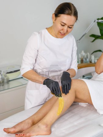 Photo for Woman cosmetologist performs sugaring peeling on her legs. High quality photo - Royalty Free Image