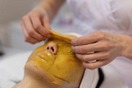  A girl at a cosmetologist does cosmetic procedures. Alginate mask. High quality photo
