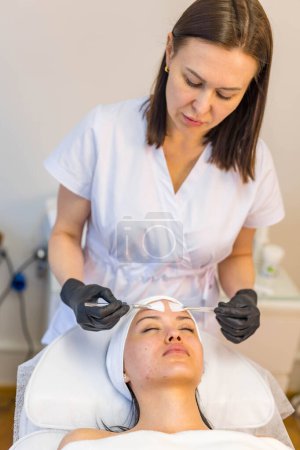 Téléchargez les photos : Un cosmétologue-esthéticien traite les problèmes de peau. Photo de haute qualité - en image libre de droit