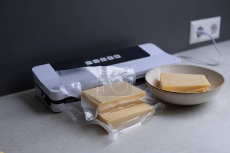 Vacuum machine and a piece of vacuum-packed cheese. High quality photo