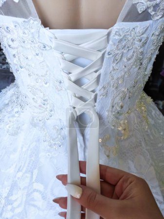 white satin dress for a wedding, lacing on a dress, engagement, wedding, fabric, lace, veil, tailoring, manicure, dressing a dress, groomsman for a wedding, assistant for a wedding,