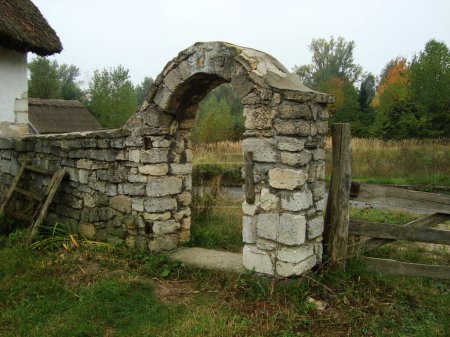 old, stone, antique, medieval gate with brown stone, blocks. village settlement, small abandoned town, stone houses, hobbit house