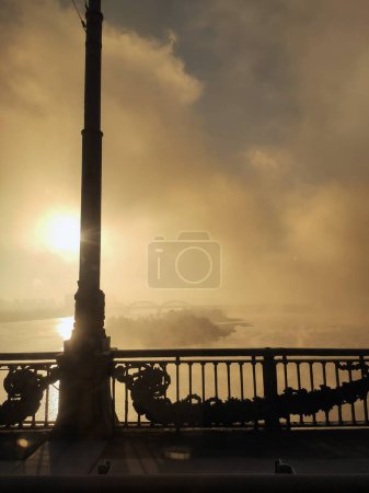 ville brumeuse de Kiev. Vue du pont à la rivière Dniepr. Matin, soir, brouillard orange, pilier