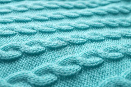 Téléchargez les photos : Macro close-up : délicat tricot turquoise avec des points visibles ressemblant à un motif tressé. Vue latérale : perspective angulaire, texture laine bleue - en image libre de droit