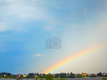 rainbow over the shore of a river lake. seven-color rainbow in the sky after the rain in a semicircle