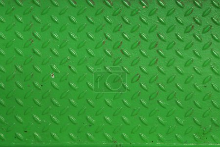 Grunge-Stahl-Bootsbodenplatte lackiert lebhaft grüne Anti-Rost-Farbe. Rauten formen Muster. Robuster Fährschiffboden aus Metall. Modernes Designkonzept. Fabrikstil. Abstrakter Hintergrund.